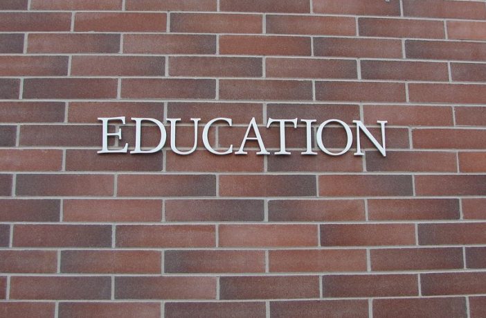 Brick wall with letters spelling education written on it