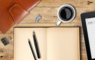 A notebook, iPad and a cup of coffee