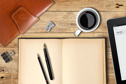 A notebook, iPad and a cup of coffee