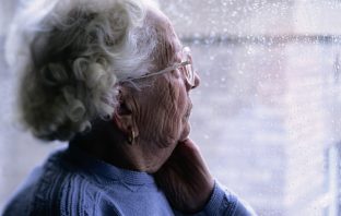 Elderly woman looking out of a window. Image credit: Thinkstock