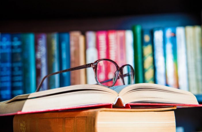 glasses and book on background bookcase close up. Thinkstock