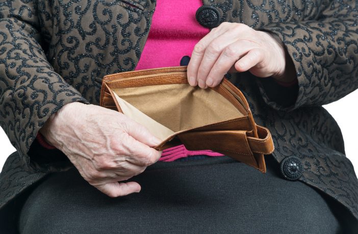 Empty wallet in the wrinkled hands of an old woman, close-up