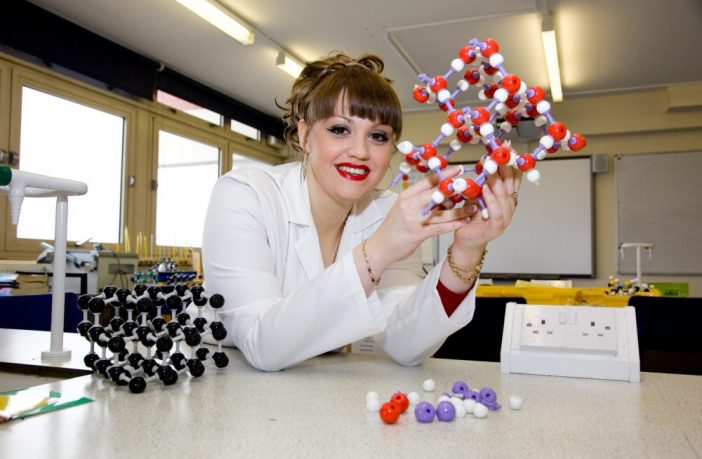 Amy King holding a model of a molecule