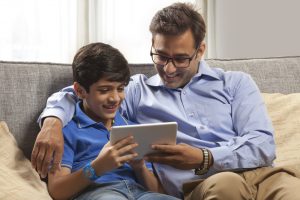 Parent teaching son with a tablet