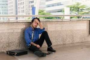 Depressed man sitting on bridge in a smart shirt