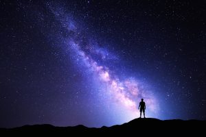 Photograph with background of Milky Way and silhouette of person
