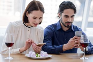 couple on smartphones at dinner