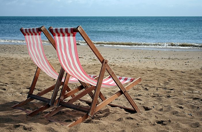 Photograph of two deckchairs on a beach