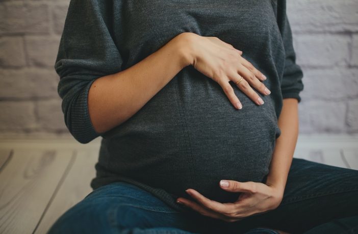 Pregnant woman with hand on belly