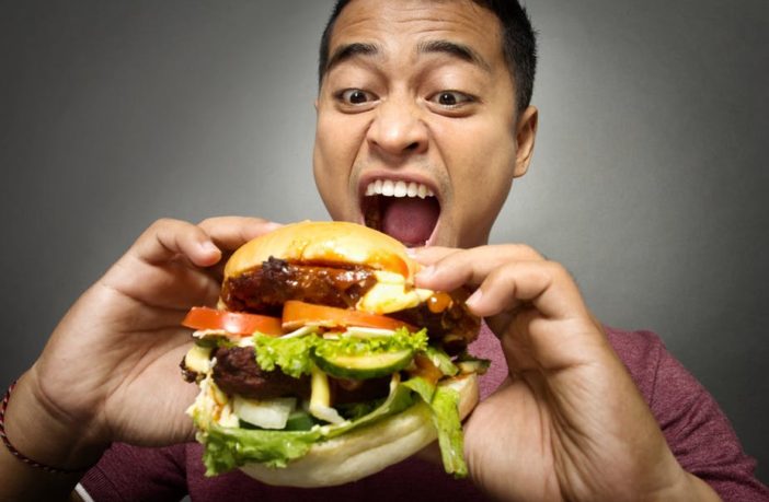 Man eating a huge burger