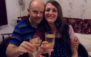 Donna and her husband toasting with a glass of champagne