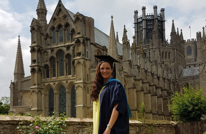 Emma Roache stood outside Ely Cathedral in her graduation robes