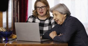 Elderly mother and daughter use computer