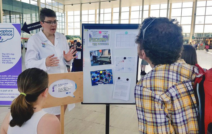 Barbara explaining her work as a LA-ICP-MS technician to a father and his daughter in the Milton Keynes shopping centre during the 2019 Soapbox Science event.