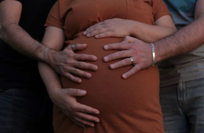 Pregnant woman with hands on her stomach