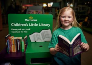 Child pictured next to the Morrisons' Children's Little Library
