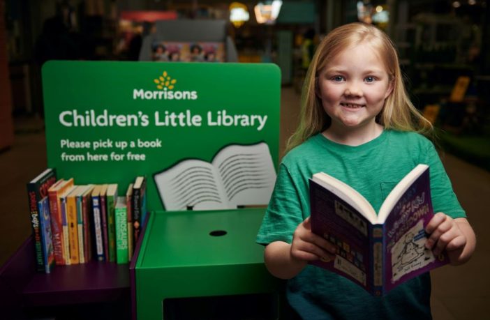 Child pictured next to the Morrisons' Children's Little Library