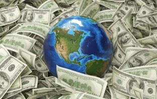 Image of a globe laying amongst dollar notes