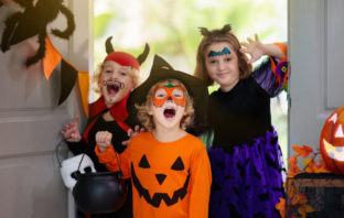 Three children dressed in costume for Halloween