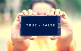 Woman holding a phone with the words true and false on the screen