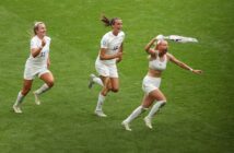 Three women from the England football celebrating their win