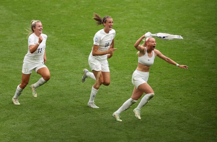 Three women from the England football celebrating their win