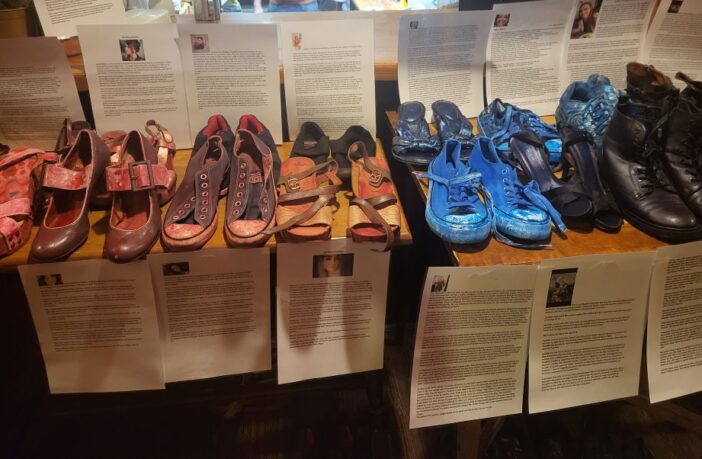 Image shows a table of shoes painted blue and red