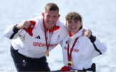 Gregg and rowing partner Lauren wearing Team GB kit, smiling at the camera with Paralympic Gold medals around their necks.